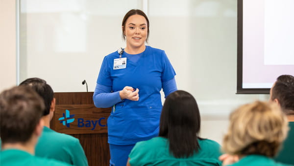 Nurse presenting to group of techs