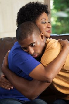 A black female hugging a younger black male.