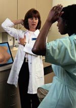 Picture of a female physician teaching a patient how to perform a self-breast examination