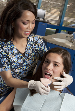 Dental assistant making mold of patient's teeth.