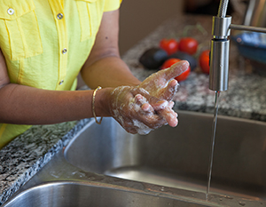 Closeup of hands being washed with soap and water.