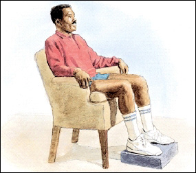 Image of man in chair sitting with legs up on a footrest