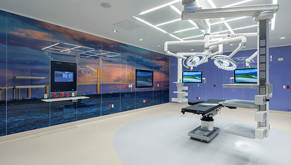 An empty operating room with a chair and surgical equipment