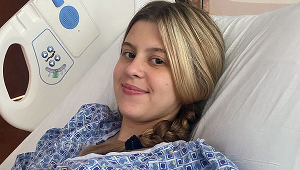 Erin Ambrose smiling in a hospital bed