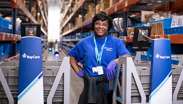 smiling baycare employee working in the bisc warehouse