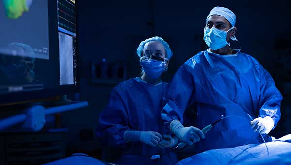two cariac surgeons in scrubs inside operating room