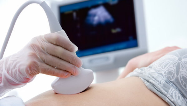 pregnant woman on hospital bed getting sonogram