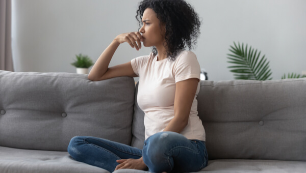 woman sitting and thinking on the couch
