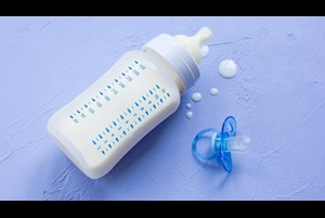 Bottle of milk for a newborn and a blue silicone soother