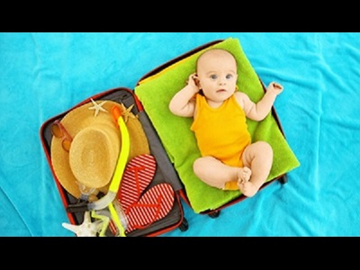 Cute baby and things for vacation in suitcase