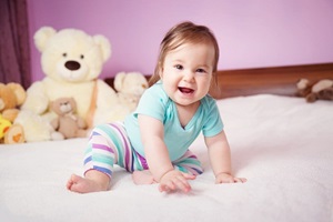 Seven month old infant child on white soft blanket