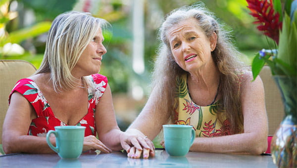 Two women commiserating over coffee