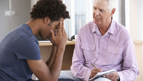 A young man is talking with a counselor.