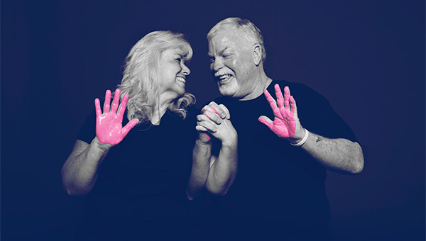 A senior man and woman participate in the "It's in Our Hands" breast cancer awareness campaign.