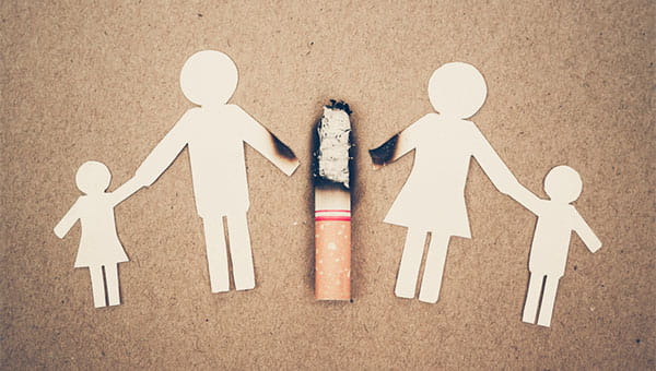 Figures made out of paper being burned by a cigarette