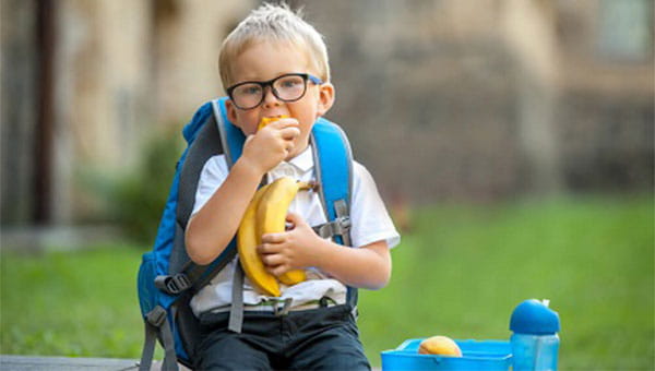 A little boy eating lunch at school
