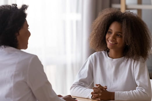Preteen female speaking with female physician