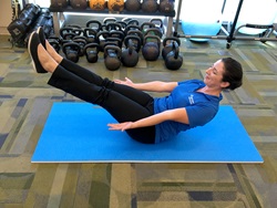 A woman demonstrates the boat pose exercise.