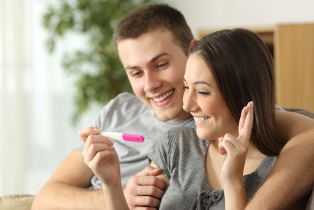 A happy couple waits for the result of a home pregnancy test.