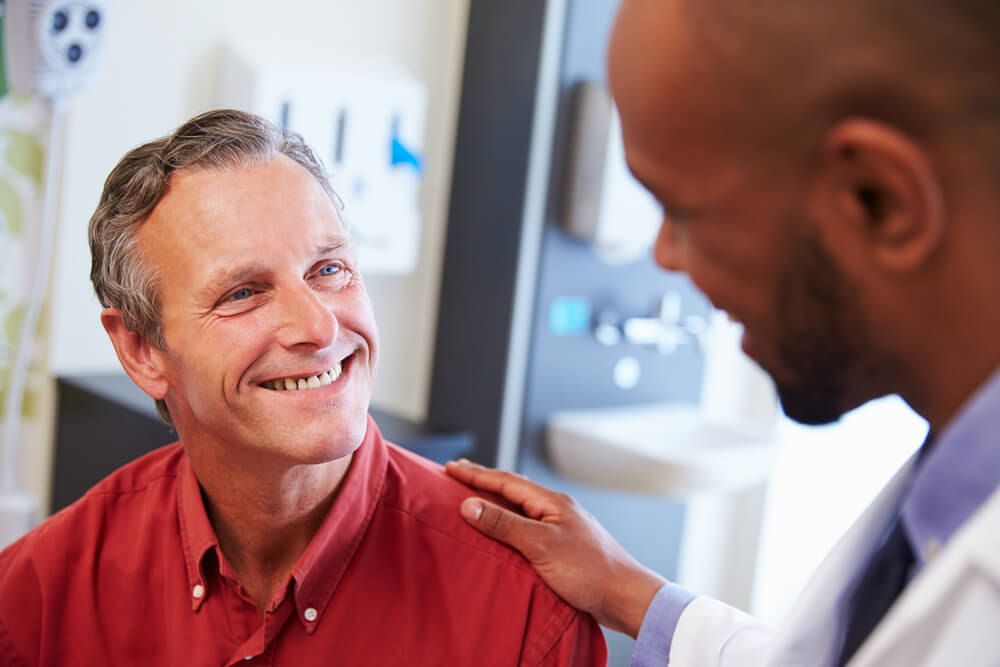 physician reassuring mature male patient
