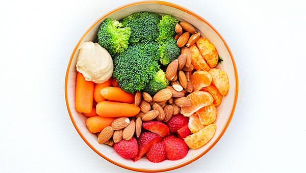 A bowl of vegetables, fruit and nuts
