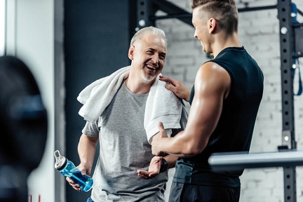 Two mature males greeting each other at a gym