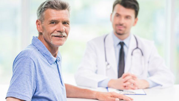 An older man talks with his primary care physician.
