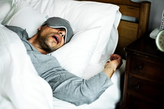 A man sleeping while wearing an eye mask