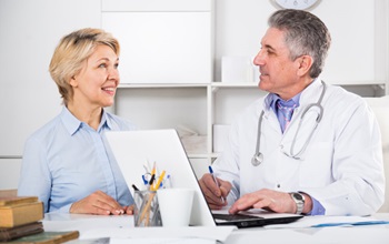male physician talking to a mature female patient