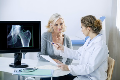 A woman discusses her bone density screening results with her doctor.