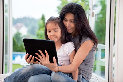 Child sitting in her mom's lap, having a virtual doctor's visit