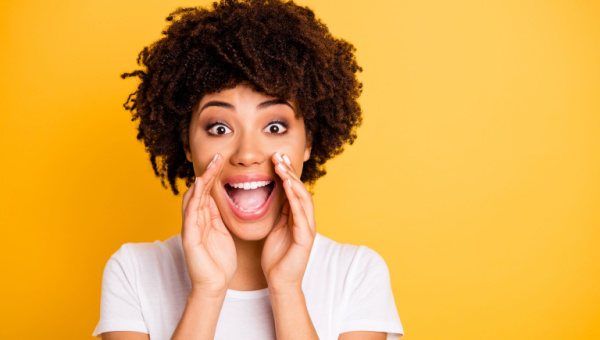 excited woman with solid yellow background