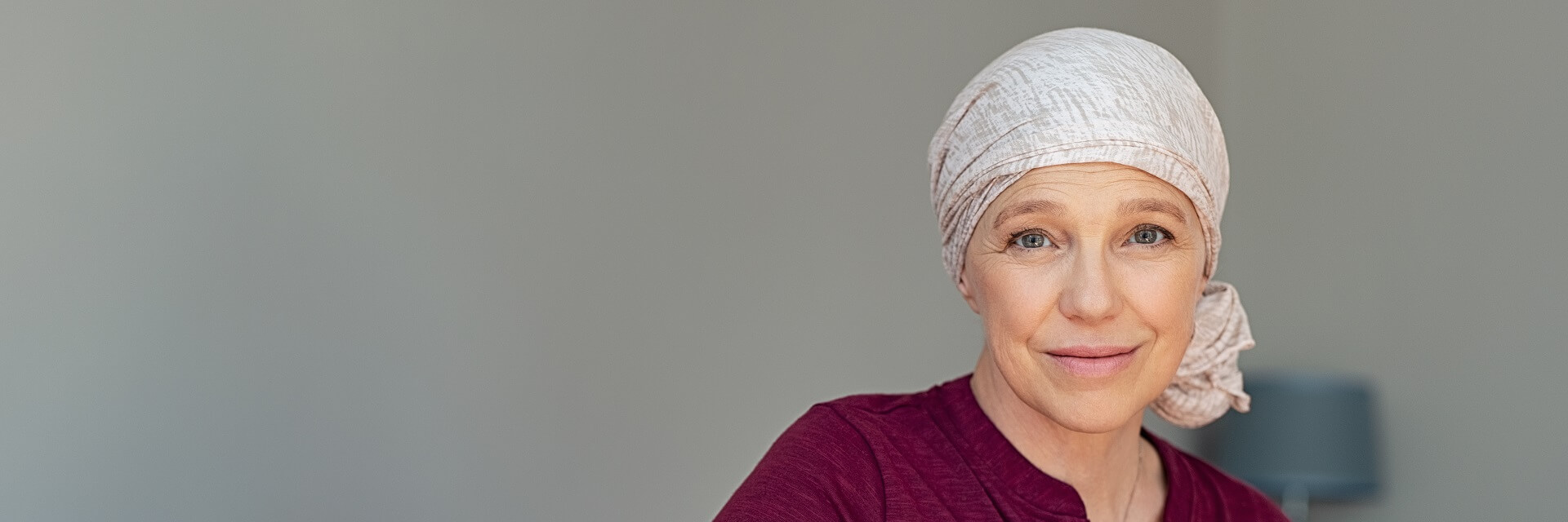 A female cancer survivor is wearing a head scarf.