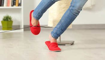 Close up of a woman legs stumbling with an electrical cord at home