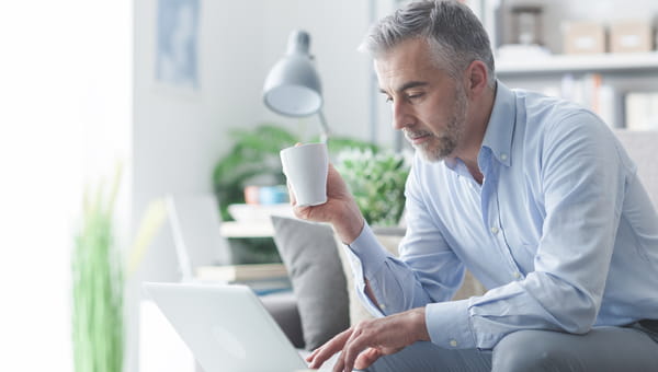 man drinking coffee while on a laptop