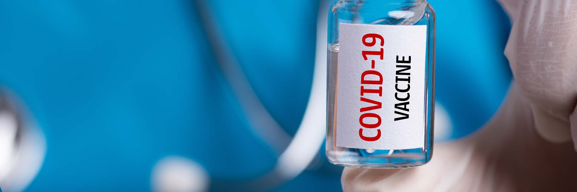 A healthcare provider is holding a bottle of the COVID-19 vaccine.