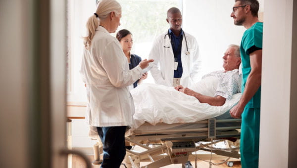 hospital room with a care team and a patient in bed