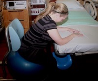 A woman demonstrating a maternity birthing position, option 2