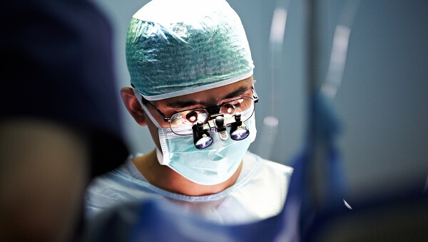 a surgeon wearing glasses and PPE