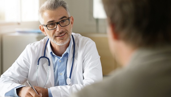 A patient is talking with his physician during an office visit.