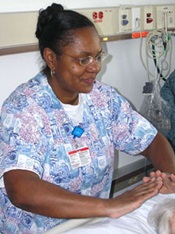 Nurse with purple pattern scrub top spending time with a patient