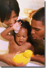 Mom and dad giving baby a bath with a rubber duck