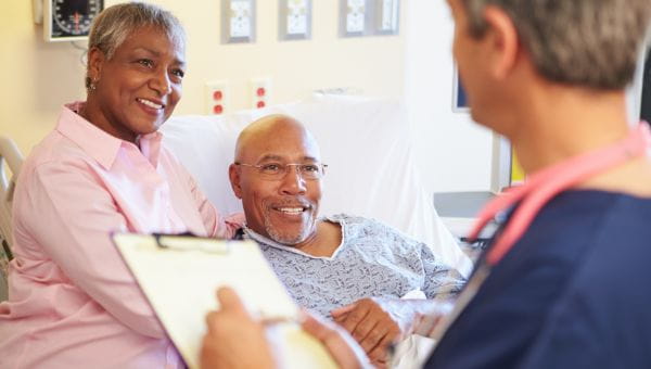 Male patient with wife listening to nurse