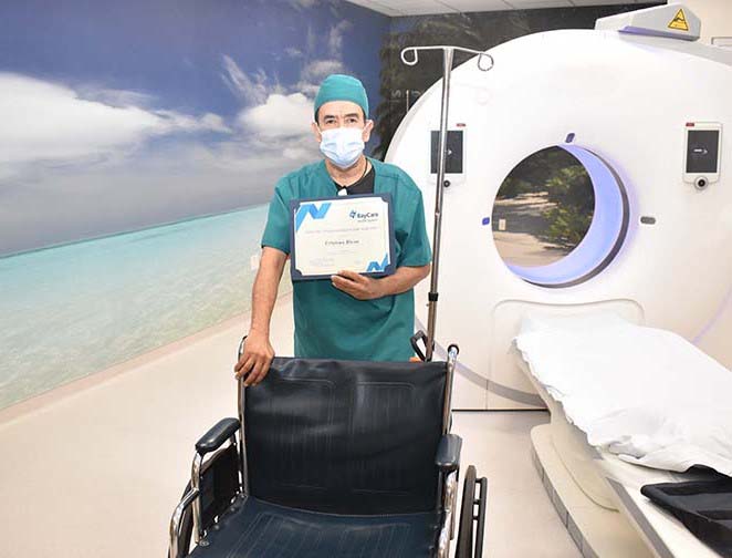 Cristian Rivas standing in back of a wheelchair in a St. Joseph's Hospital-North ER imaging room