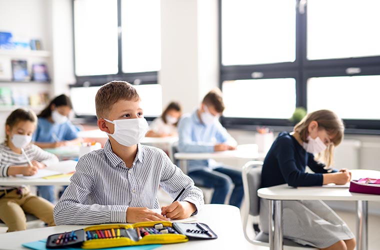 Children with face masks back at school during pandemic. 