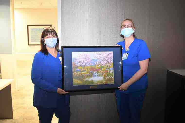 Nurses Lisa Cotroneo and Bridget Farnsworth hold Robert Sakoff's painting