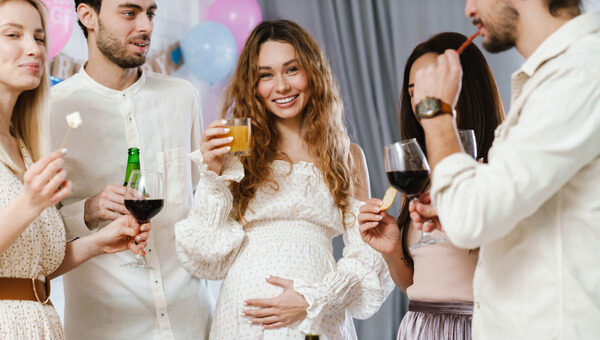 pregnant woman surrounded by her friends with alcohol