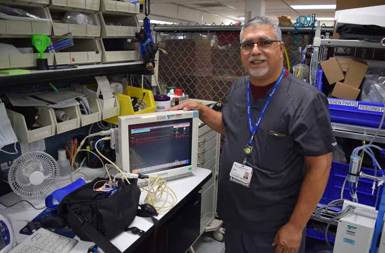 Elvin Velez stands in his work station at St. Joseph's Hospital, where he helps test, maintain and repair biomedical devices.