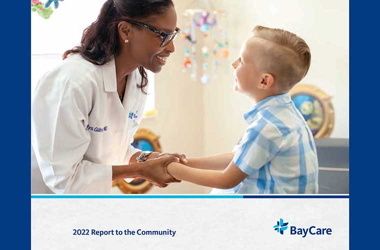 A photo of the cover of BayCare's 2022 Report to the Community. The cover photo features BayCare Medical Group pediatrician Dalys Gilling with a young boy who is her patient. 