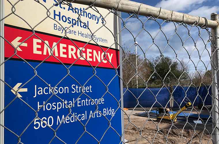 A close-up look at the hospital's directional signage located behind a fence where construction is underway.